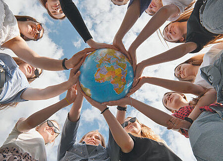 groupe étudiants tiennent ensemble un globe terrestre